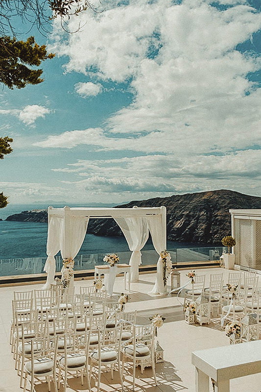 Best wedding venues in Santorini - Ultimate Guide by a local Cinematographer 14 Beautiful wedding ceremony in the terrace of Le Ciel Santorini one of the top places to get married in Santorini Imerovigli